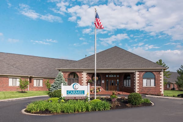 Exterior view of a senior living facility with flag