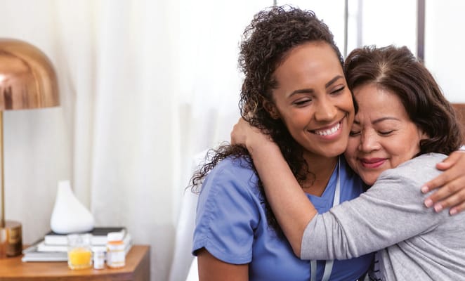 Caregiver and resident sharing a warm embrace