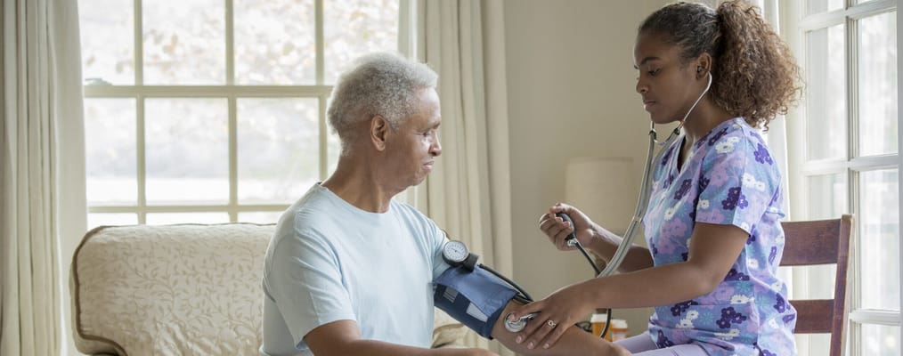 Healthcare worker taking a resident's blood pressure