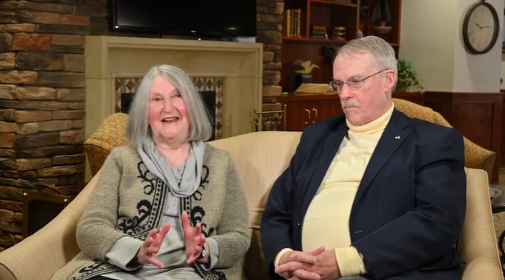 Two residents sitting on a couch in a common area