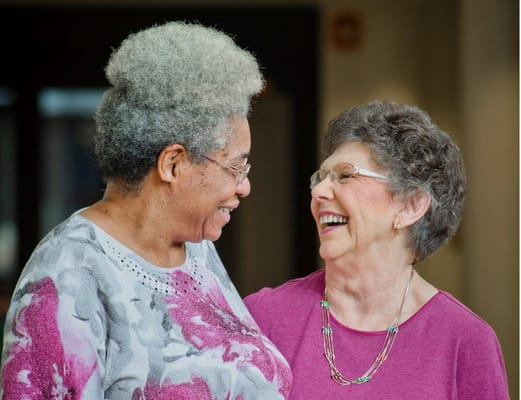 Two residents sharing a joyful moment in the facility