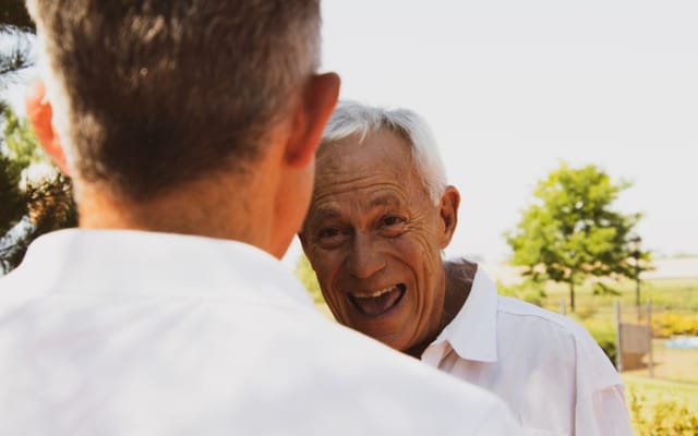 Two seniors smiling and engaging outdoors