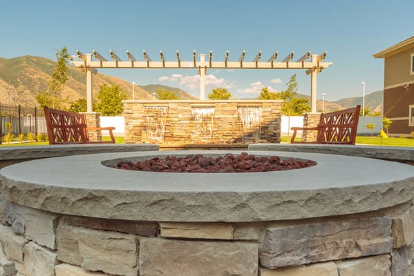 Outdoor fire pit area with benches and landscaping