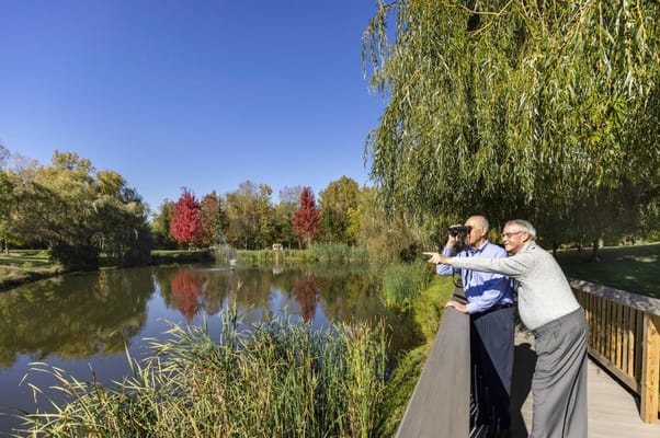 Two residents enjoying a scenic view by the pond