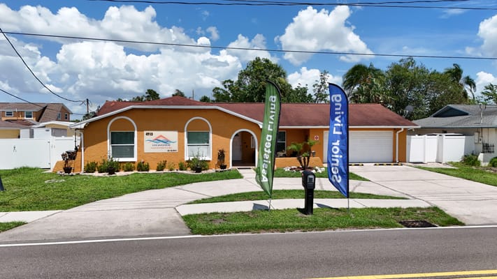 Front view of Ocean Breeze Assisted Living Facility with flags