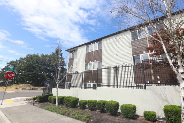 Side view of Cascade Park Gardens with landscaped shrubs and a stop sign.
