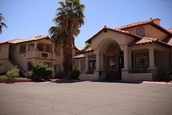 Exterior view of Oakey Assisted Living facility with palm trees