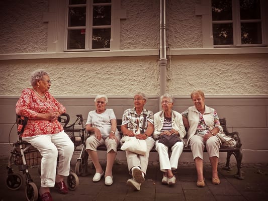 Residents sitting together on a bench outside