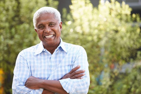 A smiling senior man outdoors in natural light