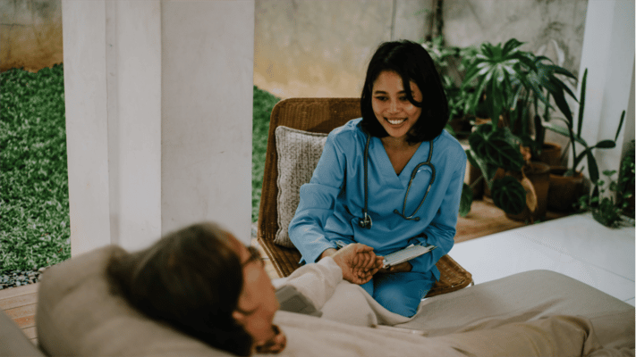 A nurse interacting with a senior resident outdoors
