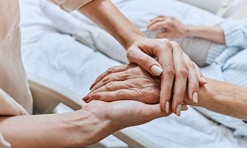 Caregiver holding hands with a senior resident