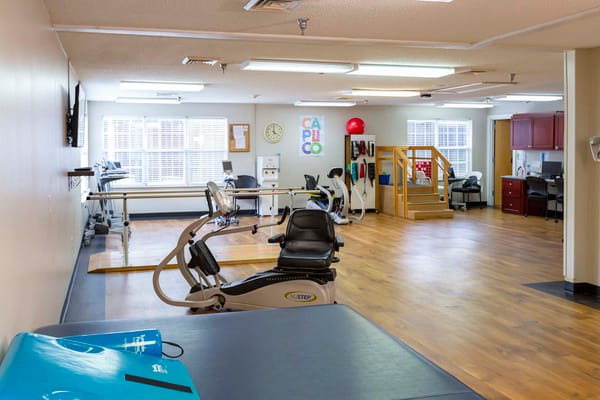 Rehabilitation gym with exercise equipment and bright lighting