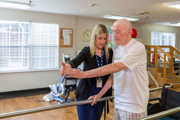 Staff assisting a resident in a rehabilitation session