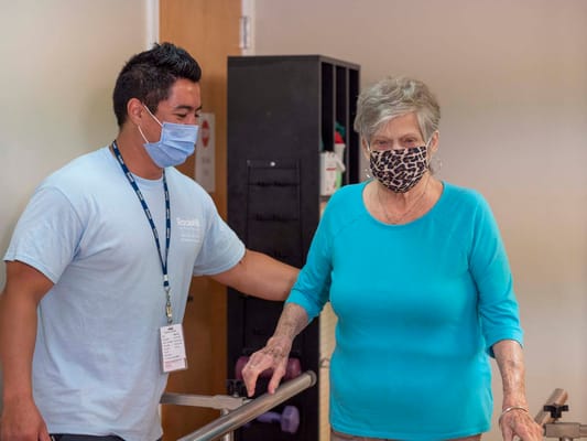 A staff member assisting a resident during therapy