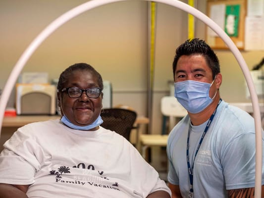 A resident and staff member posing together in a care facility