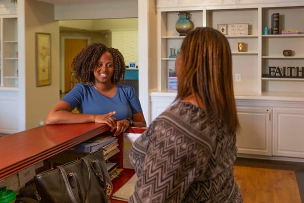 Staff assisting a visitor at the reception desk