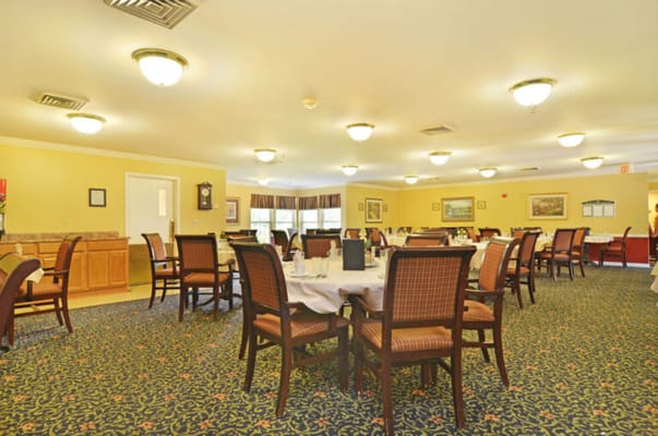 Dining room with tables and chairs set for residents
