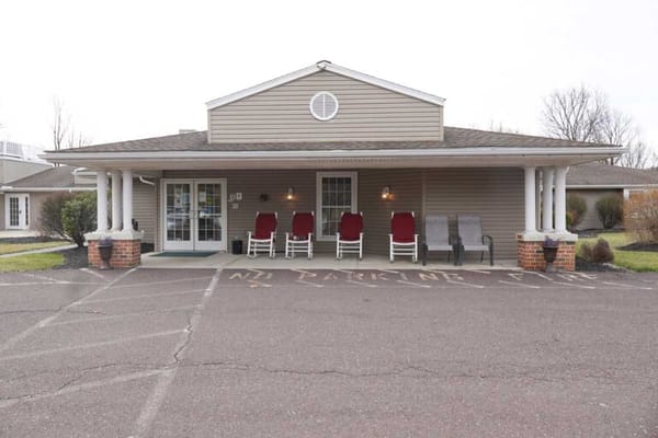 Front entrance of a senior living facility with chairs