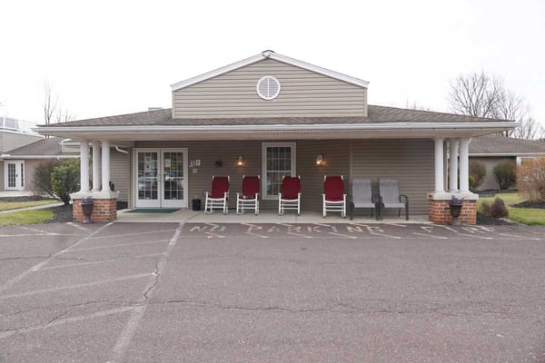 Front entrance of a senior living facility with chairs