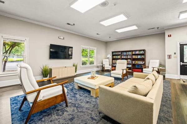 Bright common area with comfortable seating and shelves of books