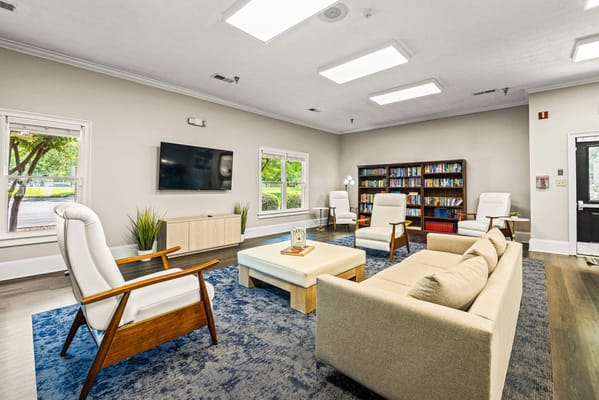 Bright common area with comfortable seating and shelves of books