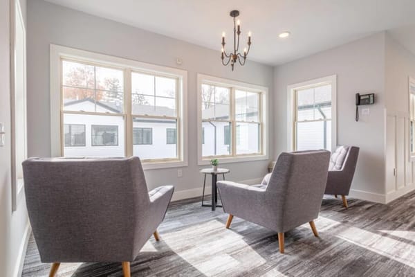 Bright common area with two armchairs and large windows