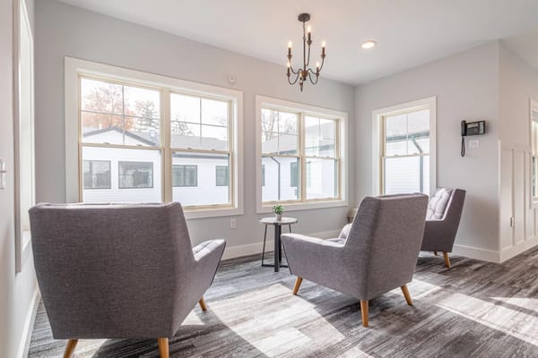 Bright common area with two armchairs and large windows