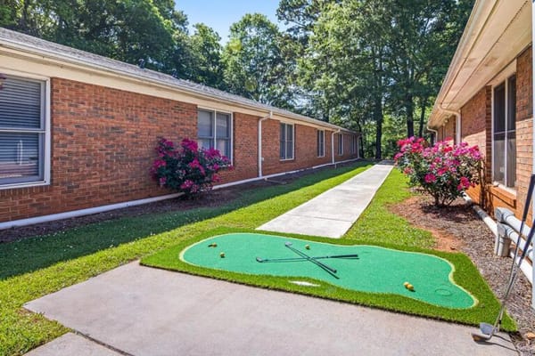 Outdoor putting green with vibrant landscaping