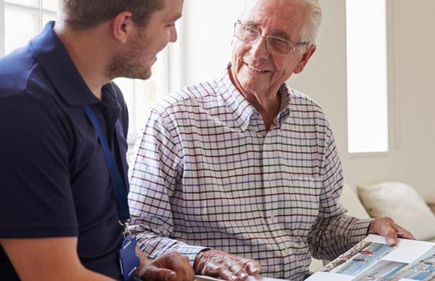 A caregiver and a resident sharing memories through photos