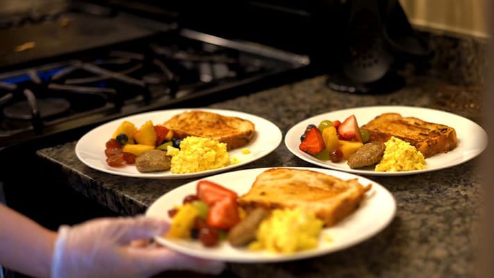 Plates of breakfast served in a kitchen