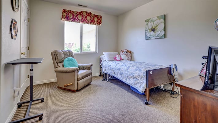 A private resident room with a bed and armchair