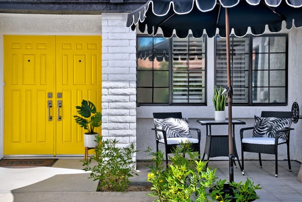 Outdoor seating area with yellow doors and plants
