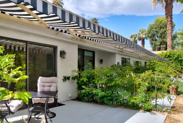 Outdoor seating area with plants and awning