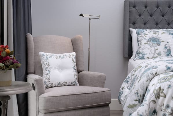 Cozy bedroom corner with armchair and flowers