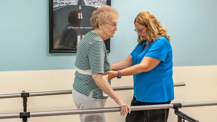 A staff member assisting a resident with rehabilitation