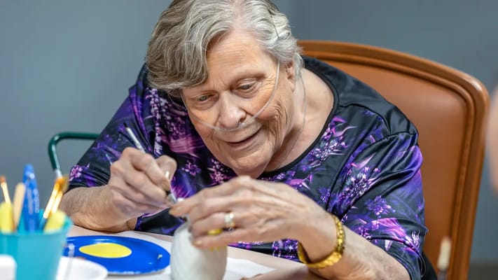 Resident painting in an activity room