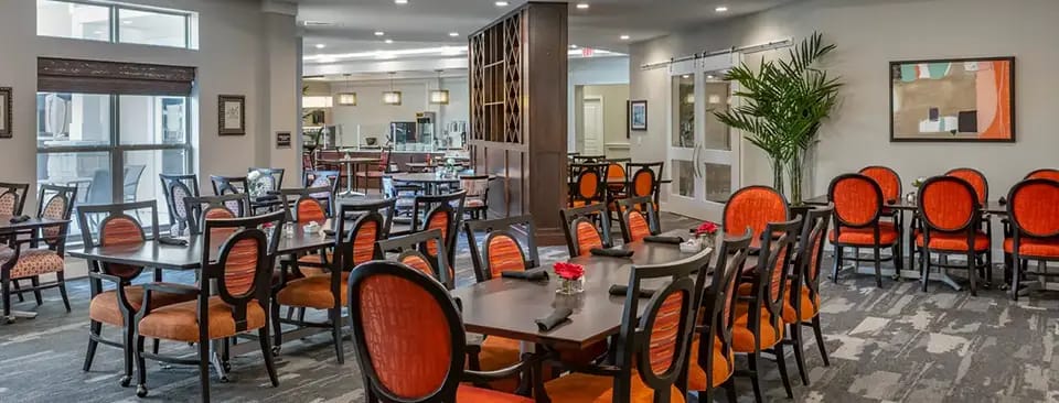 Bright dining area with orange chairs and tables