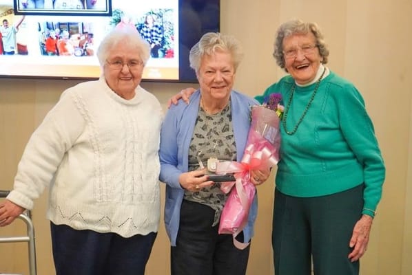 Residents celebrating with flowers and smiles