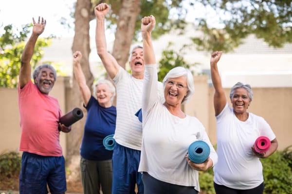 Seniors participating in a joyful exercise class outdoors