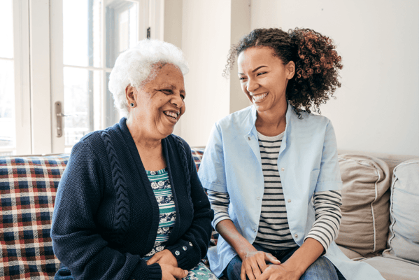 A caregiver laughing with a resident in a cozy setting