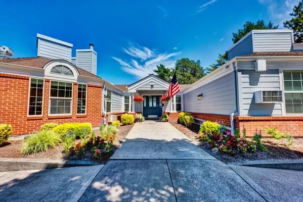 Entrance view of a senior living facility with gardens