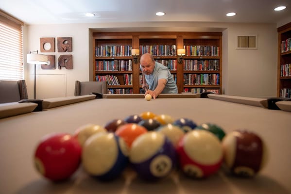 Resident playing billiards in a game room