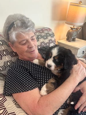 Resident holding a puppy in a cozy setting