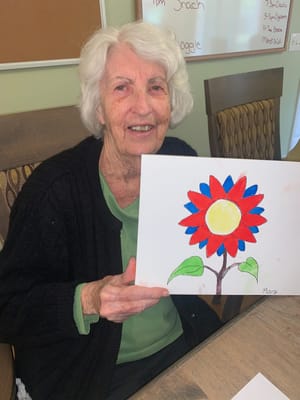 Resident showing a colorful flower painting