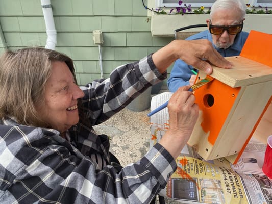 Residents engaged in a craft activity outdoors