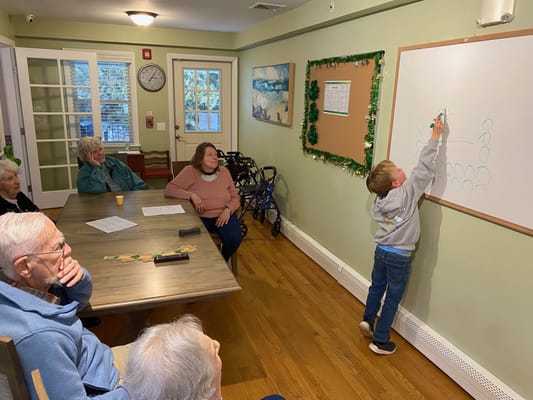 Residents watching a child at a whiteboard activity