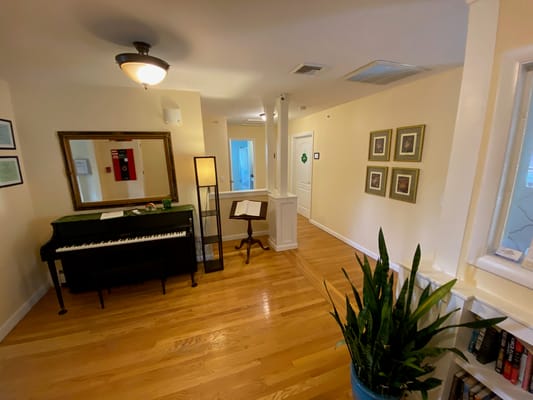Interior view of a common area with a piano and decor