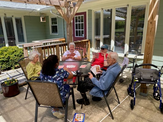 Residents playing cards in an outdoor area