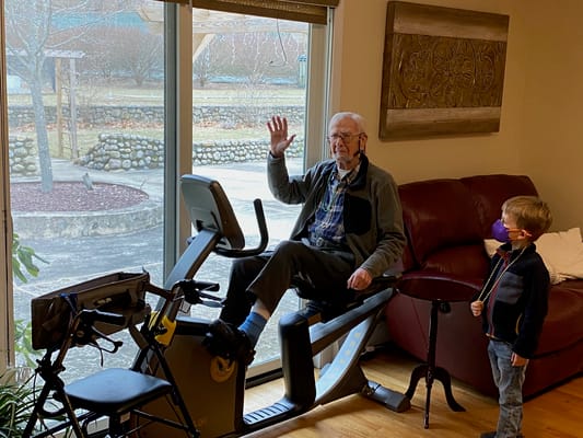 Elderly resident exercising indoors with a child nearby