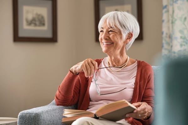 Resident reading a book in a cozy lounge